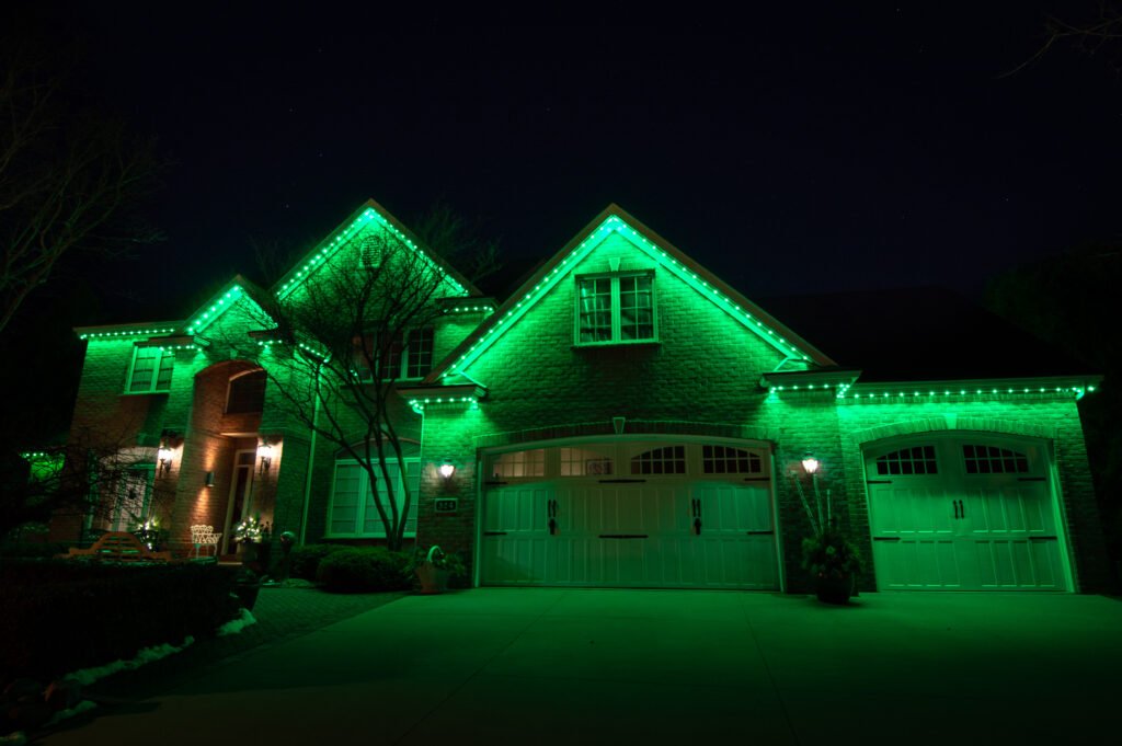 Front of a home in with Lumenary Pro permanent outdoor track lighting installed under the roofline.