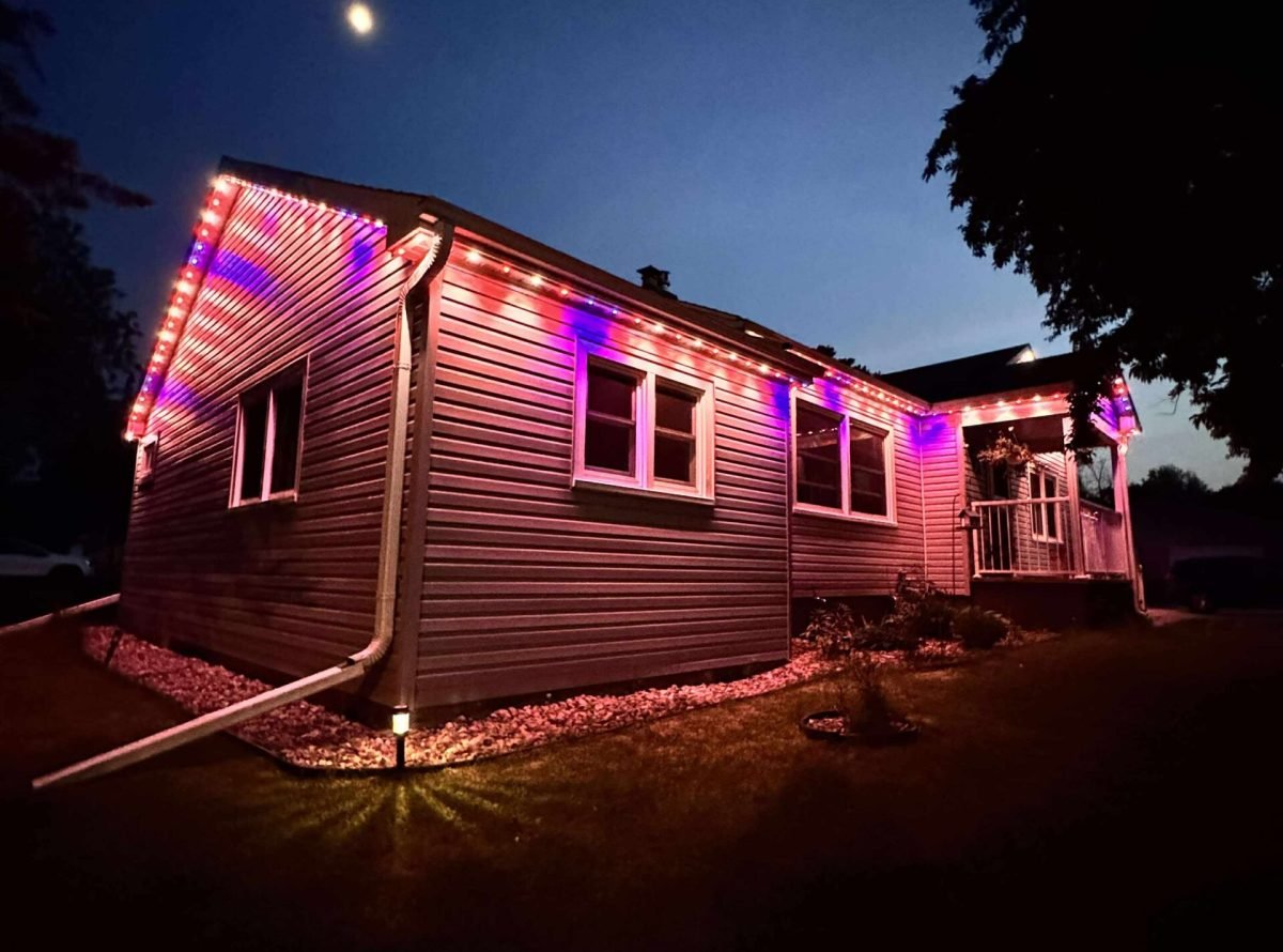 Side view of a home at night with permanent holiday lighting