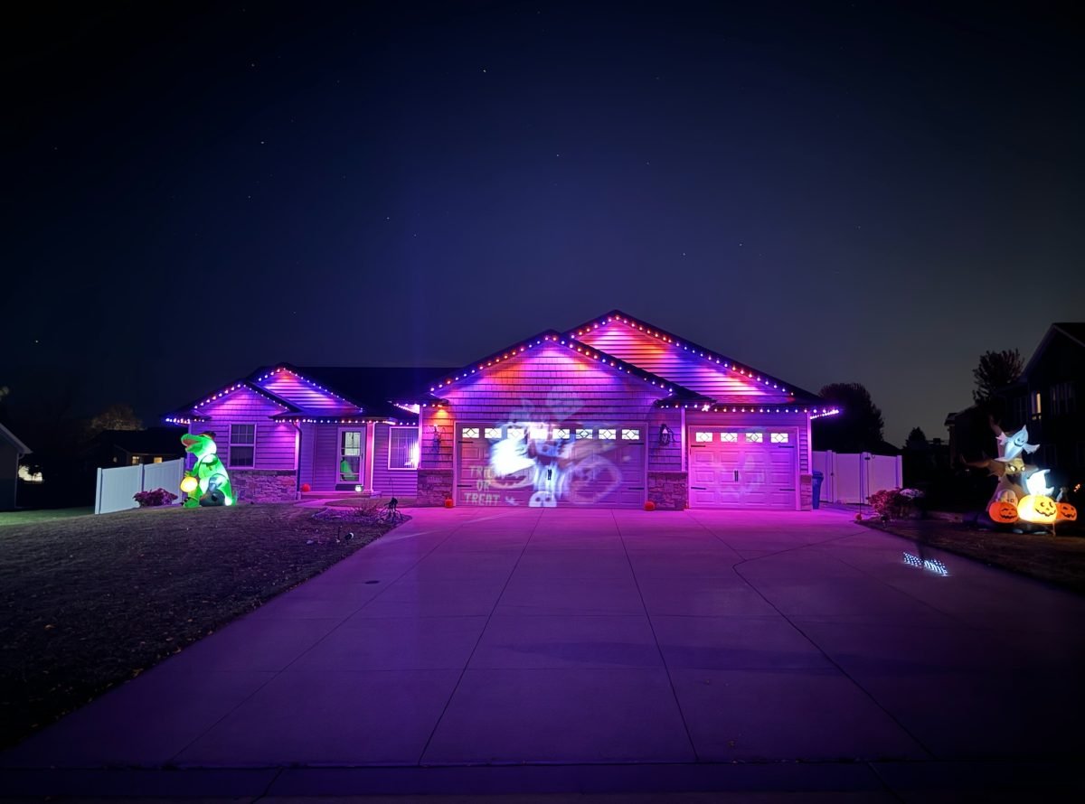 Front of a home with Lumenary Pro permanent outdoor track lighting installed under the roofline with haloween lighting on the garage door.